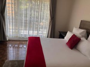 a bedroom with a large bed with red and white pillows at The Place in Umtali