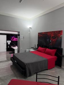a bedroom with a red bed and a tv at Elysium Luxury Suite in Trabia