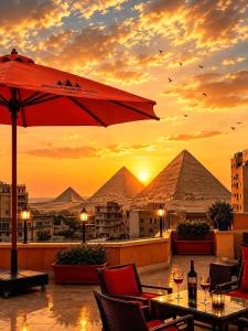 a patio with a table and an umbrella and pyramids at MiRAGE PYRAMiDS HOTEL in Cairo