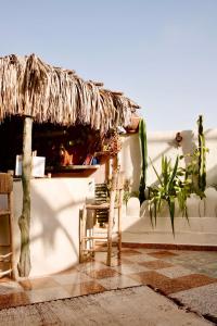 a room with a table and a straw umbrella and chairs at The FlowHost in Tamraght Ouzdar