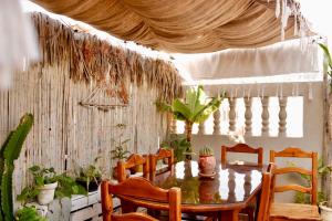 a dining room with a table and some plants at The FlowHost in Tamraght Ouzdar