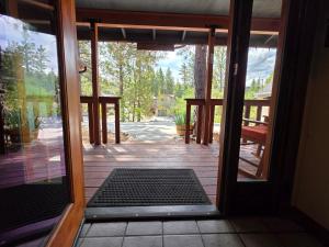 an open door to a porch with a door mat at Four Seasons Getaway-Private Hot Spa with Pine Tree Views-Walk to Village and Pineknot Trailhead-Plus King Bed! in Big Bear Lake