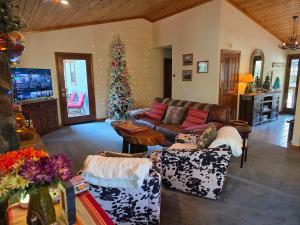 a living room with a couch and a christmas tree at Four Seasons Getaway-Private Hot Spa with Pine Tree Views-Walk to Village and Pineknot Trailhead-Plus King Bed! in Big Bear Lake