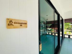 a sign on the side of a building with a pool at Chaloklumbay resort2 in Mae Haad