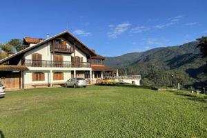 a large house with a car parked in front of it at Pousada Bela Mauá in Itatiaia