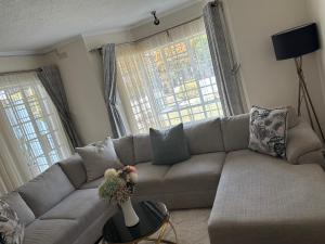 a living room with a couch and two windows at The Place in Umtali