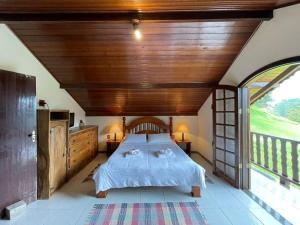 a bedroom with a large bed with a wooden ceiling at Pousada Bela Mauá in Itatiaia