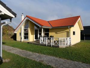 a small yellow house with an orange roof at Spa Cottage with Two Wings in Grossenbrode