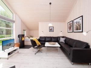 a living room with a black couch and a table at Spa Cottage near Baltic in Grossenbrode