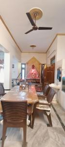 a dining room with a table and a ceiling fan at Sharan Homestay in Ayodhya