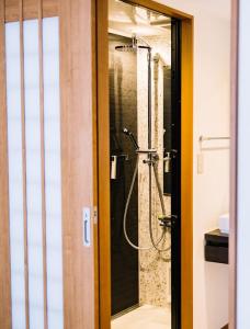 a shower in a bathroom with a glass door at Momo Lodge Madarao in Iiyama