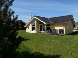 a small house with a porch and chairs in a yard at Spa Cottage near Baltic in Grossenbrode