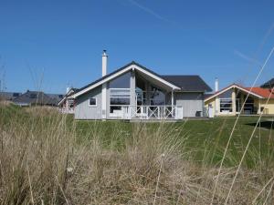 a house with a large porch on a lawn at Spa Residence near Shore in Grossenbrode