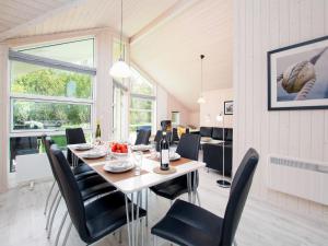 a dining room with a table and black chairs at Split-Wing House for Eight in Grossenbrode