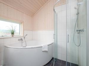 a bathroom with a tub and a glass shower at Split-Wing House for Eight in Grossenbrode +15 photos