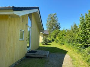a house with a bench next to a building at Split-Wing House for Eight in Grossenbrode