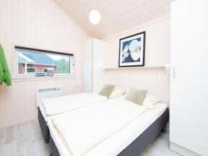 two beds in a room with a window at Split-Wing House for Eight in Grossenbrode