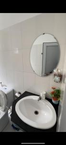 a bathroom with a white sink and a mirror at Hotel Song biển in Phan Thiet