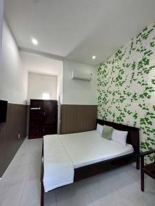 a bedroom with a bed with a green wall at Hotel Song biển in Phan Thiet