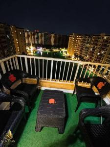 a balcony with chairs and a table with a view of a city at Portogolf elalamin in El Alamein
