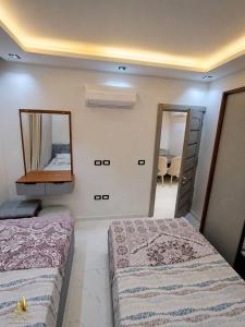 a bedroom with two beds and a mirror at Portogolf elalamin in El Alamein