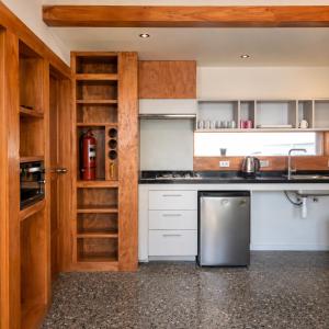 a kitchen with white cabinets and a stainless steel refrigerator at Refugio Cordillera Flora endógena Bosque Esclerófilo in San José de Maipo