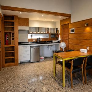 a kitchen with a table and a table and chairs at Refugio Cordillera Flora endógena Bosque Esclerófilo in San José de Maipo +23 photos