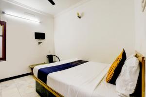 a bedroom with a bed in a white room at SPOT ON JAYAM RESIDENCY in Chennai