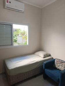 a small bedroom with a bed and a window at Morada do Mazza in Boituva