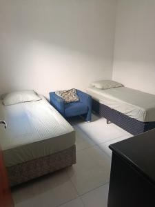 a room with two beds and a blue stool at Morada do Mazza in Boituva