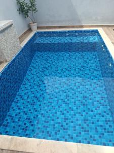 a swimming pool with blue tiles on it at Morada do Mazza in Boituva