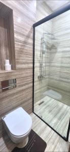 a bathroom with a toilet and a glass shower at Luxury Apartment in Tlemcen +41 photos