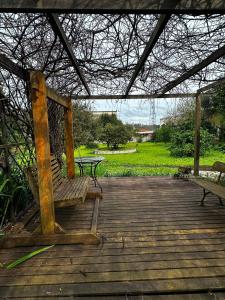 a wooden porch with a bench and a picnic table at Hospedaria do Guata in Tibagi