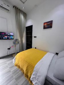 a bedroom with a bed with a yellow blanket at Tameeza stays in Sangotedo