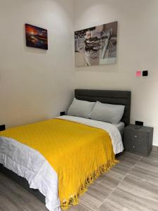 a bedroom with a bed with a yellow blanket at Tameeza stays in Sangotedo