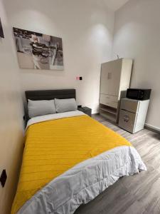 a bedroom with a yellow bed and a refrigerator at Tameeza stays in Sangotedo