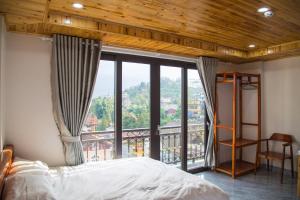 a bedroom with a bed and a large window at Sapa Station Hotel in Sapa