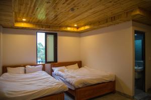 two twin beds in a room with a window at Sapa Station Hotel in Sapa