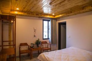 a bedroom with a bed and a table and chairs at Sapa Station Hotel in Sapa