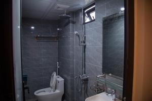 a bathroom with a shower and a toilet and a sink at Sapa Station Hotel in Sapa