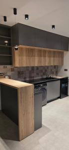 a kitchen with black cabinets and a counter top at Luxury Apartment in Tlemcen