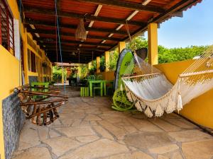 a patio with two hammocks on a building at Bananoz Surfhouse in Transito