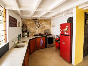 a kitchen with a red refrigerator and a sink at Bananoz Surfhouse in Transito