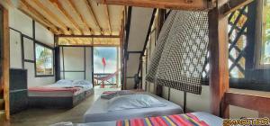 a room with three beds in a room with windows at El Rincón de Juan in San Onofre