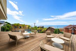 a patio with chairs and tables on a deck at IPC Resort富津竹岡 in Futtsu