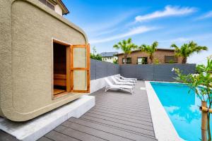 a backyard with a swimming pool and a building at IPC Resort富津竹岡 in Futtsu