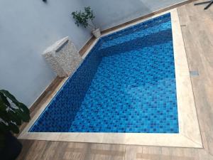 a swimming pool with blue tiles on the floor at Morada do Mazza in Boituva