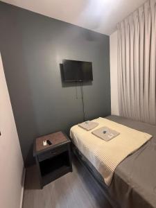 a small bedroom with a bed and a table at Edificio Z7 in San Pedro Sula