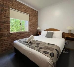 a bedroom with a large bed and a brick wall at BIG4 Tasman Holiday Parks - Warrnambool in Warrnambool +41 photos
