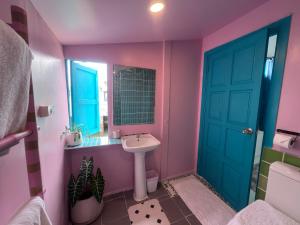 a bathroom with a sink and a blue door at The Boathouse in Bang Sare